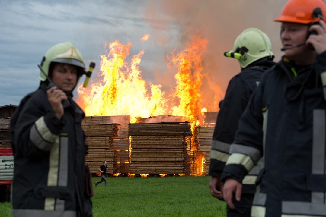 Feuerwehrleute koordinieren ihren Einsatz am Brandort in Urswil. (Bild: Dominik Wunderli / Neue LZ)