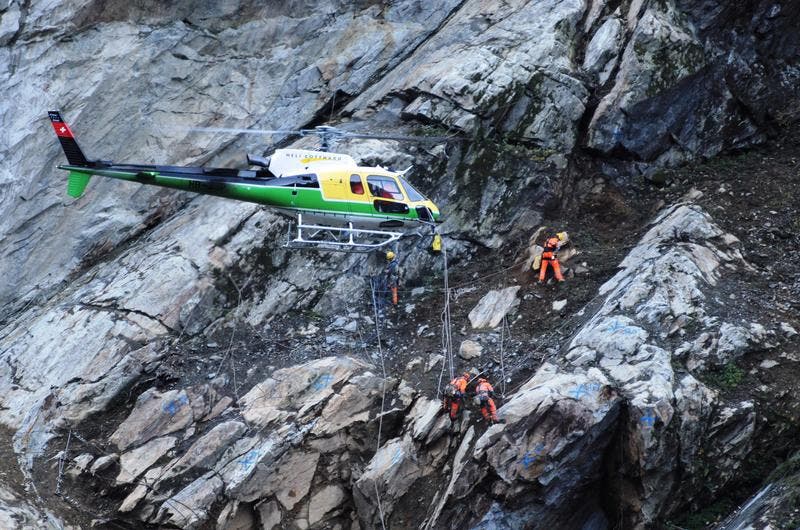 Ein Helikopter der Heli Gotthard fliegt über die Unfallstelle. (Bild: Urs Hanhart/Neue UZ)