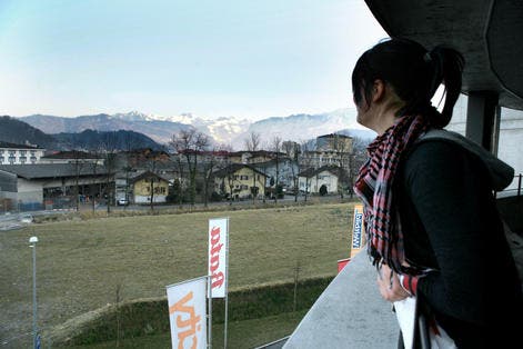 Eine junge Frau blickt auf das Feld, auf welchem das Gebäude geplant ist. (Bild Chris Iseli/Neue LZ)
