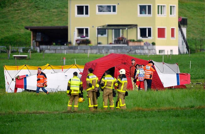 Rettungskräfte am vergangenen Dienstag bei der Absturzstelle in Kägiswil. Das Flugzeugwrack ist von einem Zelt verdeckt. (Bild: Keystone)