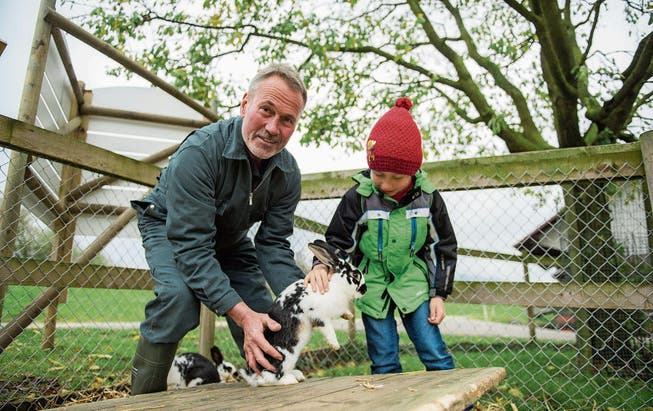 Pächter Josef Heer zeigt Besucher Danilo aus Luzern die Kaninchen auf dem Grämlishof. (Bild: Dominik Wunderli (Horw, 8. November 2017))