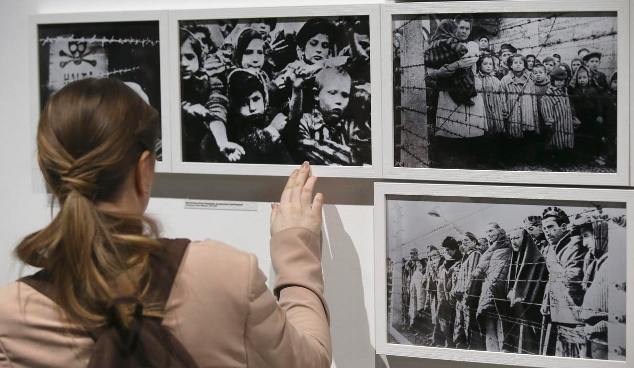Eine Besucherin schaut im jüdischen Museum in Moskau die Fotos einer Sonderausstellung zum 70. Jahrestag der Befreiung des Konzentrationslagers von Auschwitz an. (Bild: Keystone)