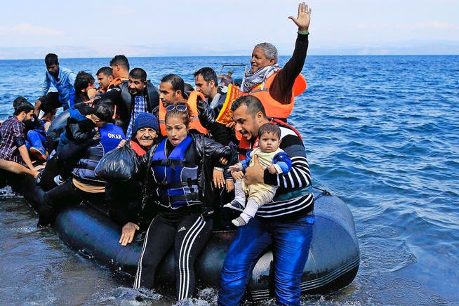 Syrische Flüchtlinge kommen aus der Türkei per Schlauchboot auf der griechischen Insel Lesbos an. Derzeit erreichen täglich bis zu 3000 Flüchtlinge die Insel. (Bild: EPA/Orestis Panagiotou)