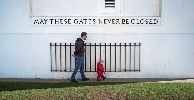 Mann und Kind beim Friedensbogen mit der Inschrift «Mögen diese Tore niemals geschlossen sein» an der US-kanadischen Grenze bei Surrey in British Columbia. Die kanadische Regierung will deutlich mehr Einwanderung zulassen. (Bild: Darryl Dyck/AP (12. Februar 2017))