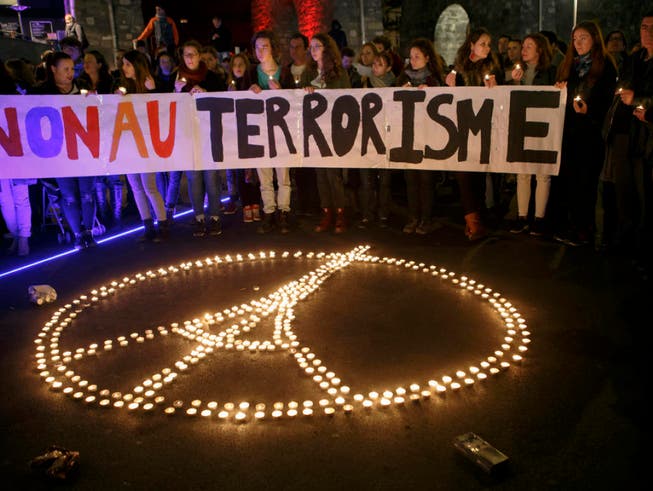 Das etwas abgeänderte Peace-Zeichen mit dem Eiffelturm im Kreis wird zum Symbol für die Solidarität mit den Opfern der Anschläge in Paris. (Bild: /KEYSTONE/SALVATORE DI NOLFI)