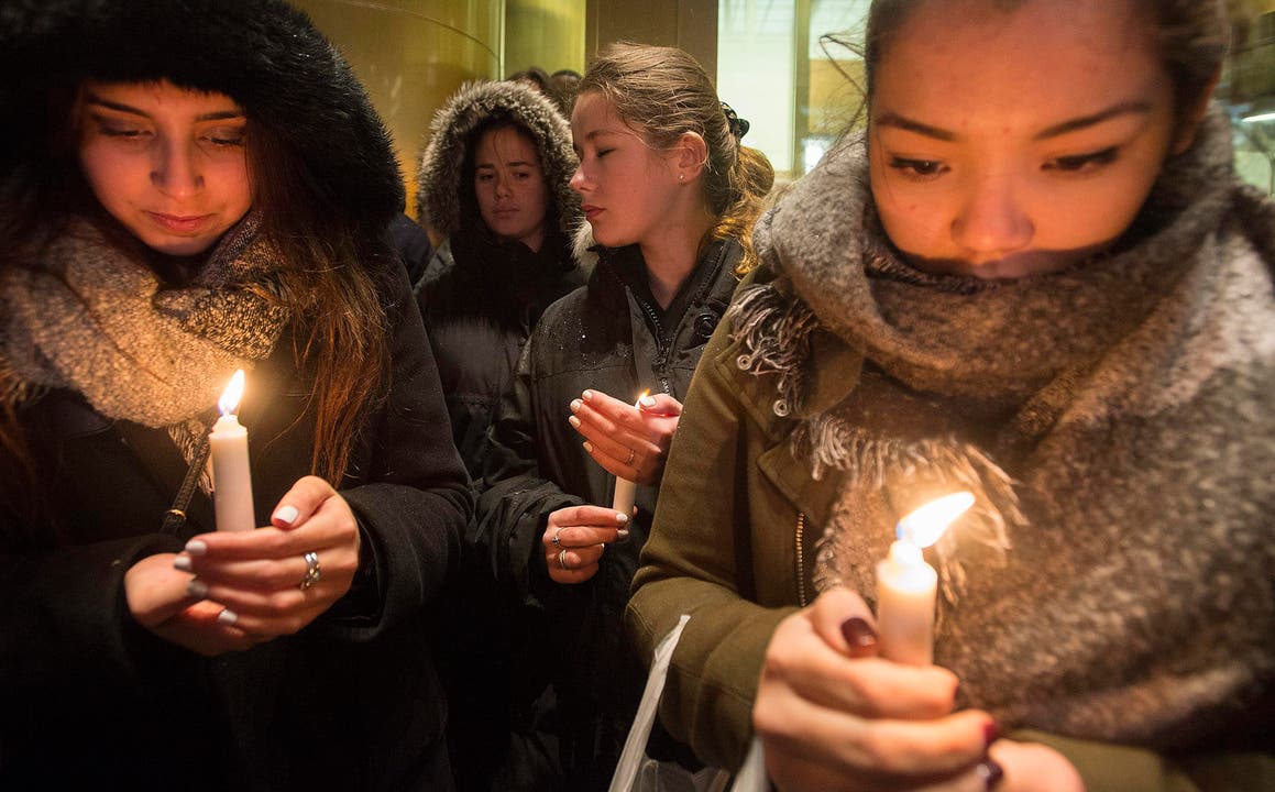 Frauen mit Kerzen vor der französischen Botschaft in Montreal. (Bild: AP/Graham Hughes)
