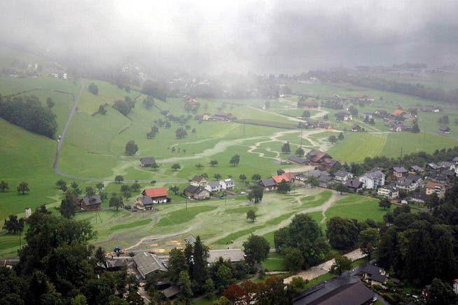 Überschwemmtes Land: Unten in der Mitte der Forsthof, der dem Hochwasserschutz weichen muss. Bild: Kapo Obwalden (Alpnach, 22. August 2005)