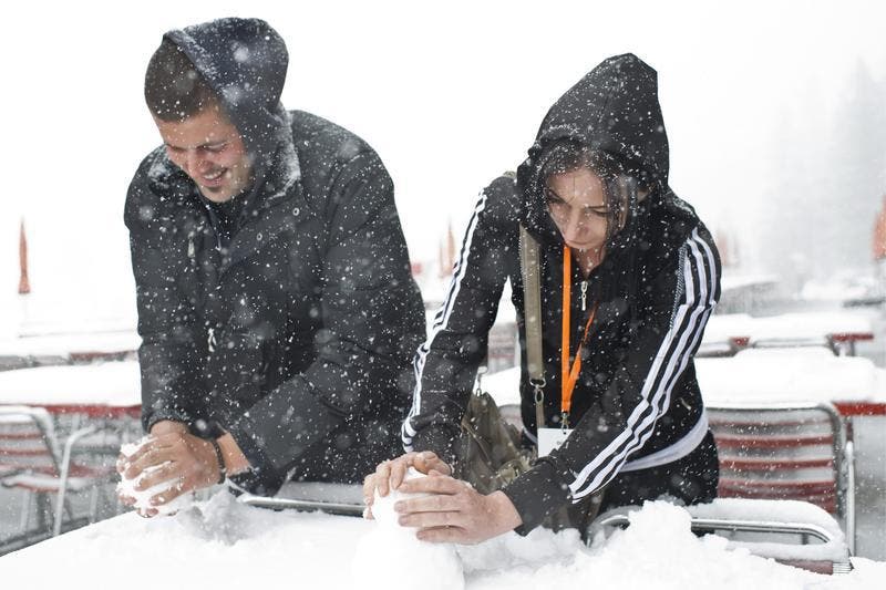 Jovo, links, und Biljana bauen aus Schnee einen kleinen Schneemann auf einem Tisch auf der Schwägalp. (Bild: Keystone)