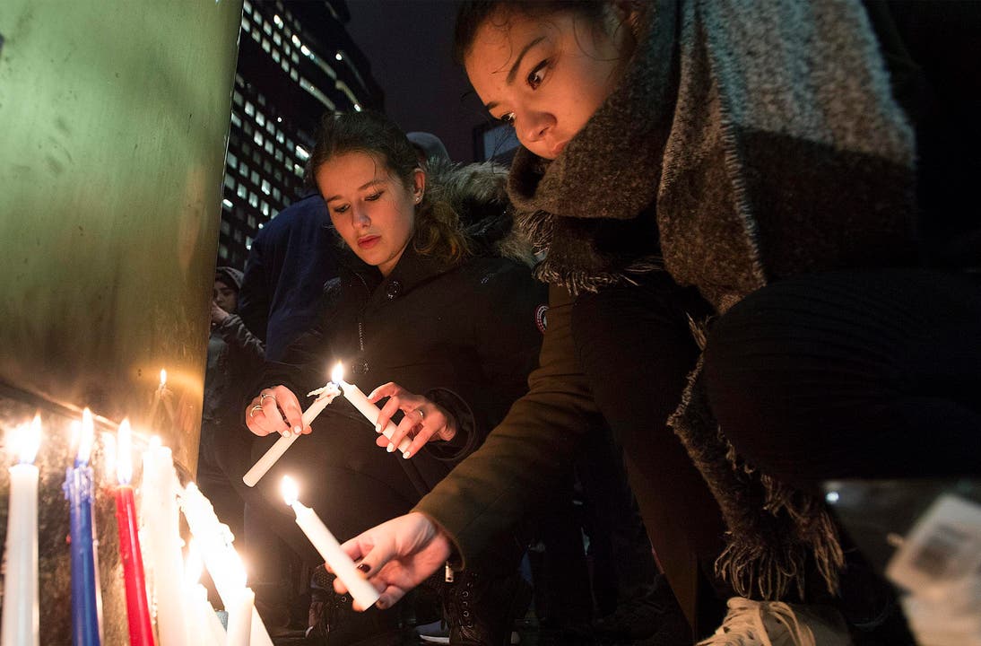 Frauen zünden Kerzen an vor der französischen Botschaft im Montreal. (Bild: AP/Graham Hughes)