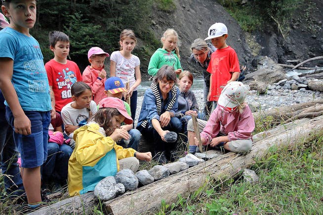 Schüler der Klasse 3b aus Giswil nehmen mit Projektleiterin Stefanie Dillier (Mitte) Töne aus der Natur für die «Ranftsuite» auf. (Bild Marion Wannemacher)