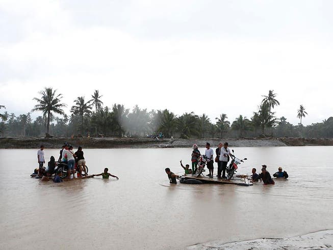 Bewohner versuchen bei der Ortschaft Salvador den Fluss zu überqueren, um sich in Sicherheit zu bringen. (Bild: KEYSTONE/EPA/JEOFFREY MAITEM)