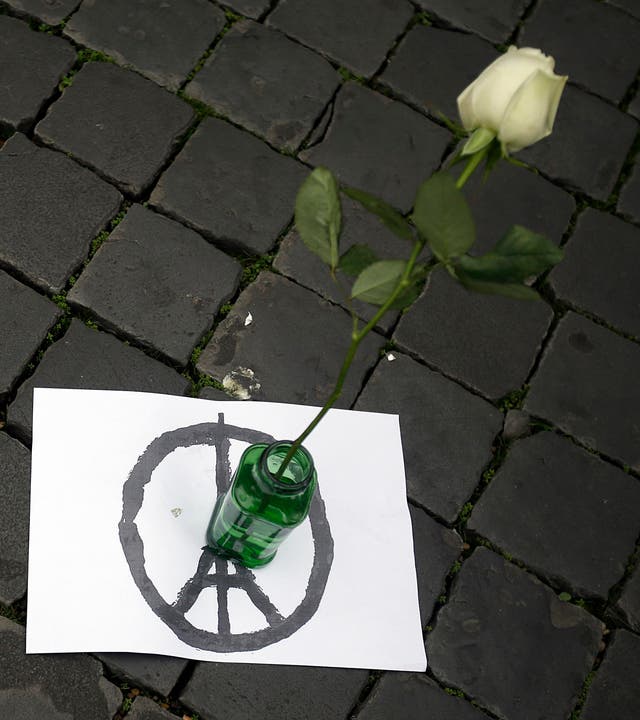 Eine weisse Rose auf einem als Friedenszeichen symbolisierten Eiffelturm vor der französischen Botschaft in Rom. (Bild: AP/Gregorio Borgia)