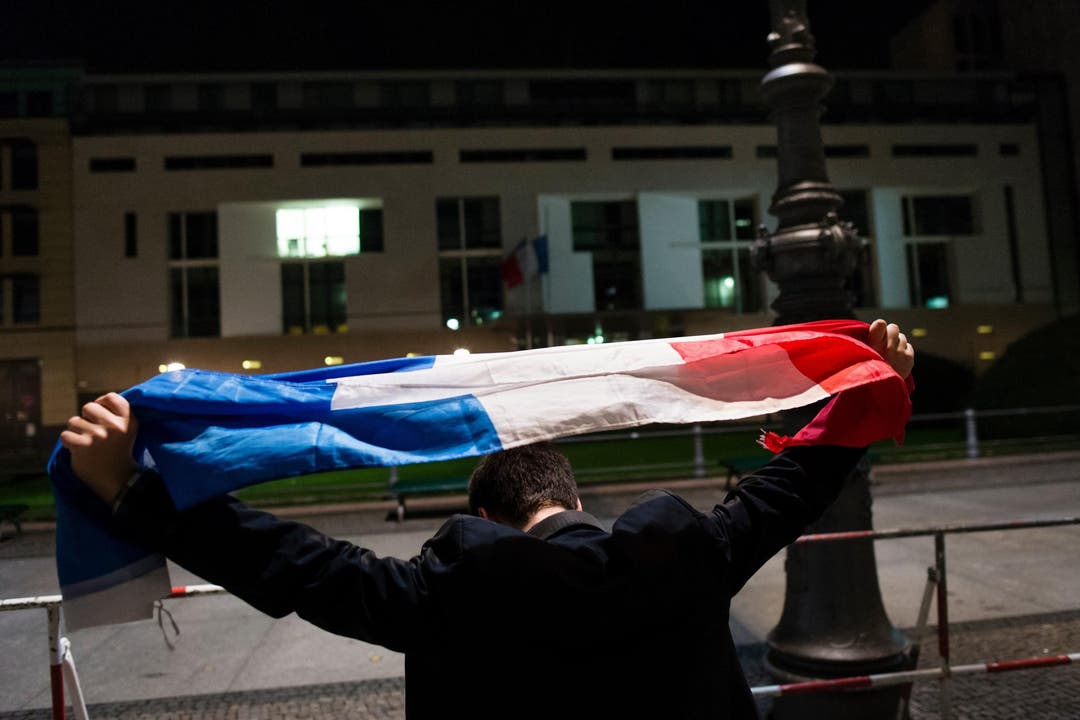 Ein Mann hält die «Tricolore» hoch. (Bild: AP/Gregor Fisher)