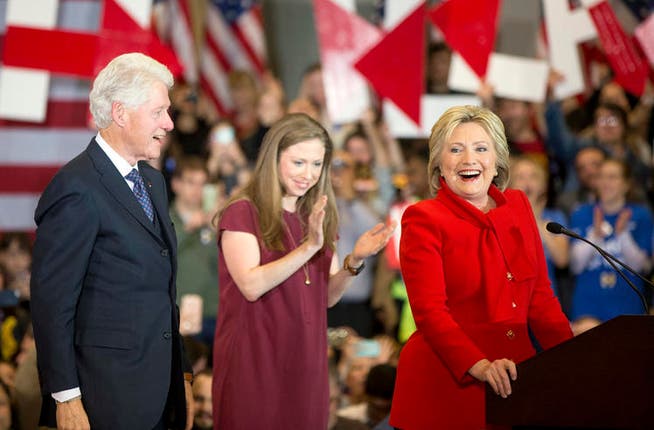 Freude über das gute Abschneiden in Iowa: Die Demokratin Hillary Clinton (rechts), in Begleitung ihres Mannes, des frühreren US-Präsidenten Bill Clinton, und Tochter Chelsea. (Bild: AP/Andrew Hamik)