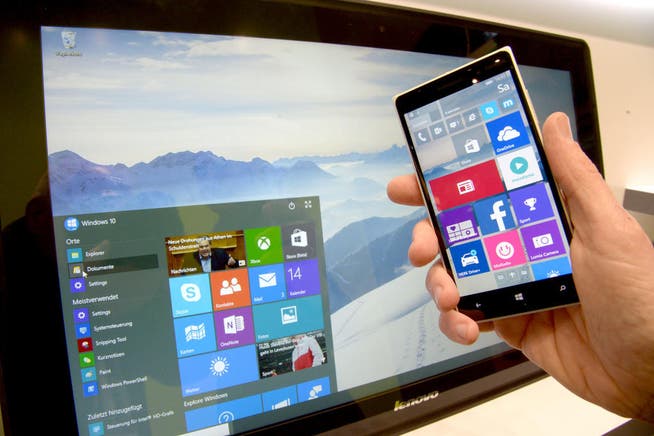 Das Betriebssystem Windows 10 auf einem PC und einem Smartphone. (Bild: Peter Steffen / DPA (Hannover, 14. März 2015))