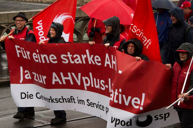 Kundgebungsteilnehmer tragen Transparente und Fahnen am traditionellen 1. Mai-Umzug in Basel. Der Tag der Arbeit steht heuer im Zeichen der AHV: Die Gewerkschaften stellen den 1. Mai unter das Motto "Gemeinsam kämpfen - für eine starke AHV". (Bild: Keystone)