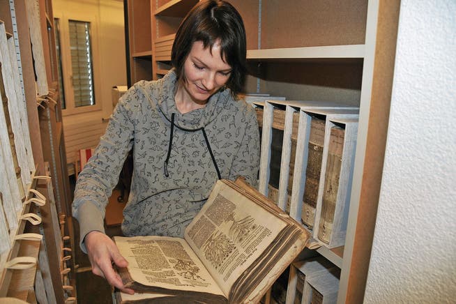 Bibliothekarin Mirjam Zürcher betrachtet ein jahrhundertealtes Buch aus dem Nachlass der Kapuziner. (Bild: Matthias Piazza (Stans, 10. März 2017))