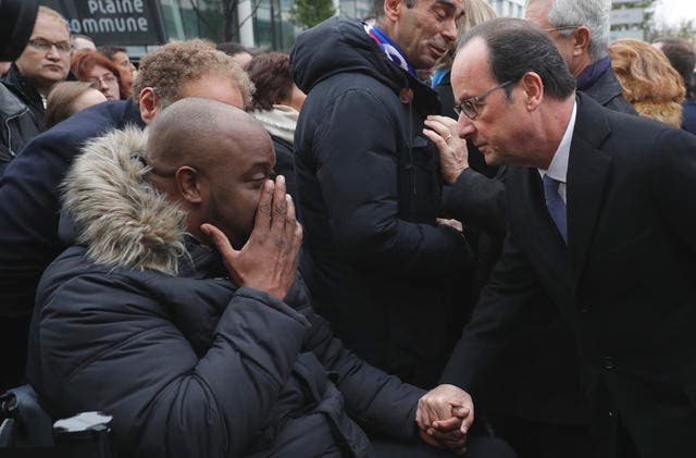 Der französische Präsident François Hollande redet mit einem Betroffenen der Pariser Anschläge bei der Enthüllungsfeier einer Gedenktafel in Paris. (Bild: Philippe Wojazer/Pool Photo via AP)
