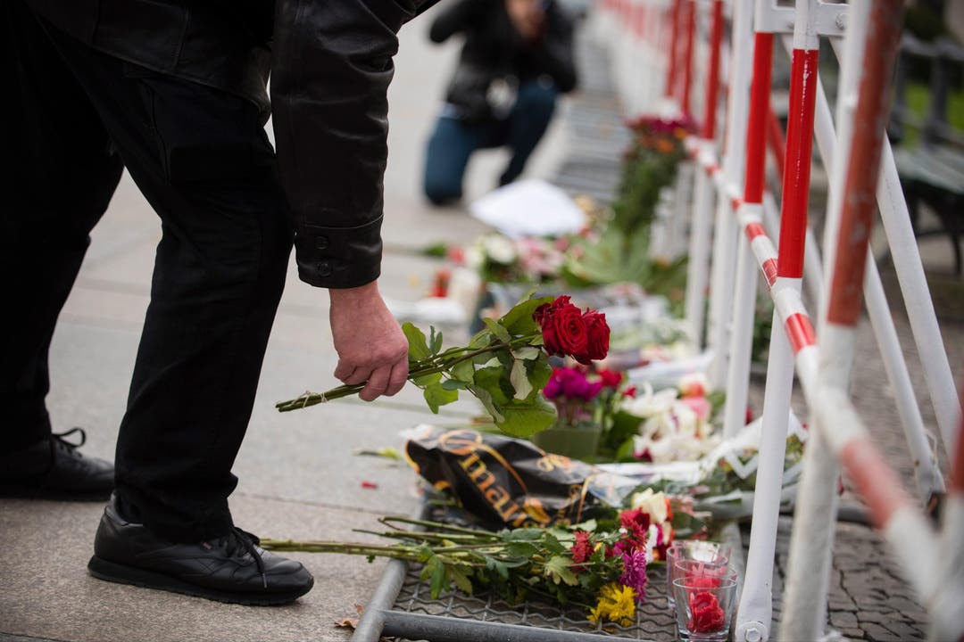Ein Mann legt vor der französischen Botschaft in Berlin Blumen nieder. (Bild: EPA/Gregor Fisher)