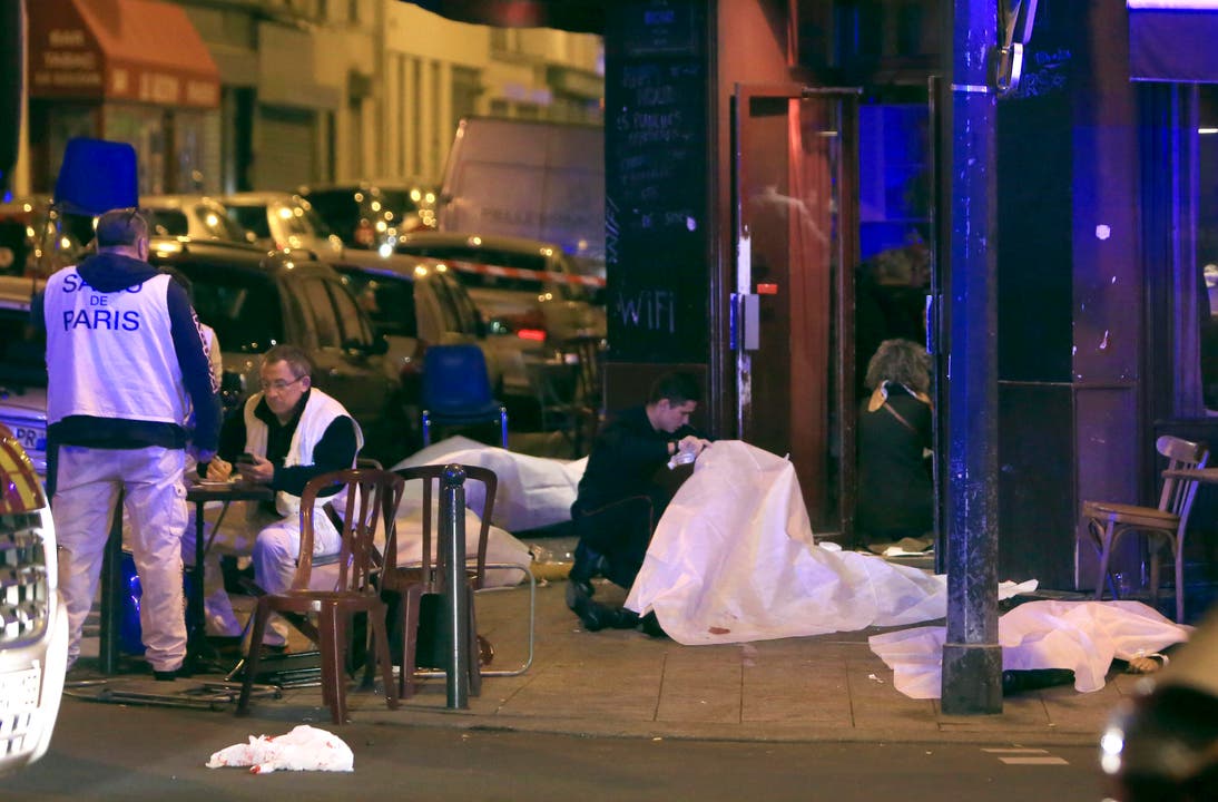 Polizisten bei der Spurensicherung, Opfer des Anschlags sind mit Tüchern bedeckt. (Bild: AP/Thibault Camus)