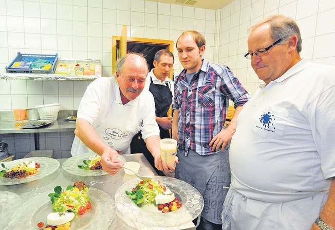 Karl Poljansek, Küchenchef am Februar-Räblus-Kochabend, instruiert sein Team, wie er den Salat hergerichtet haben will. Bruno Wöcke, Stefan Müller und Albert Nüesch (von links) werden sich daran halten. (Bilder: Max Tinner)
