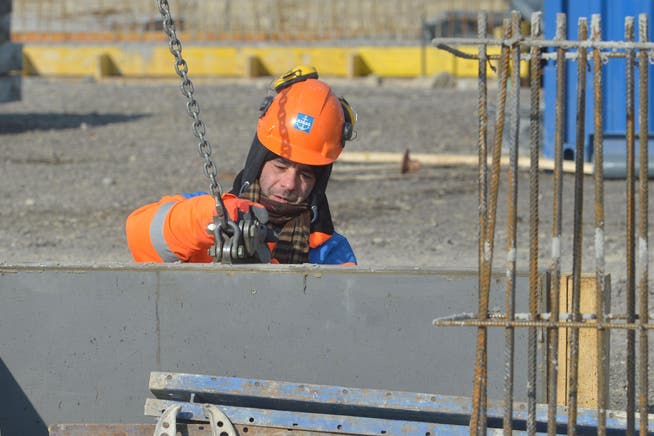 Ein Bauarbeiter kümmert sich gut eingepackt um eine Verschallung auf der Baustelle in Märstetten. (Bild: Mario Testa)