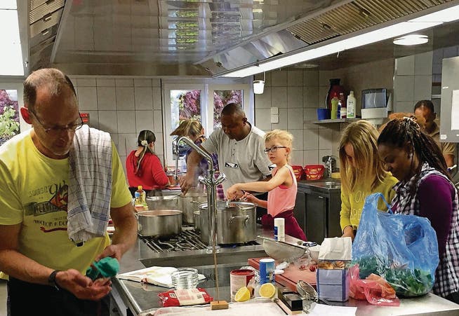 Hinter dem Herd in der «Stocken»-Küche: Schülerinnen der SBW Primaria kochen gemeinsam mit Flüchtlingen. (Bild: pd)