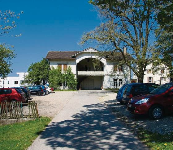 Die Parkplätze beim Schulheim Kronbühl sollen verlegt, das Haus im Hintergrund abgebrochen werden. (Bild: Simone Buff)