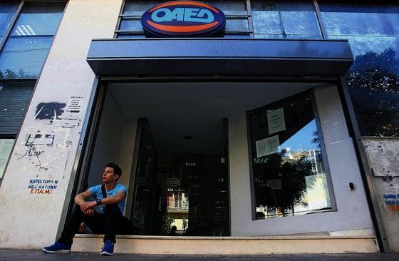 Ein junger Mann sitzt auf der Stufe eines Büros der Arbeitsvermittlung in Athen. In Griechenland sind fast zwei Drittel der Jungen ohne Job. (Bild: ap/Thanassis Stavrakis)