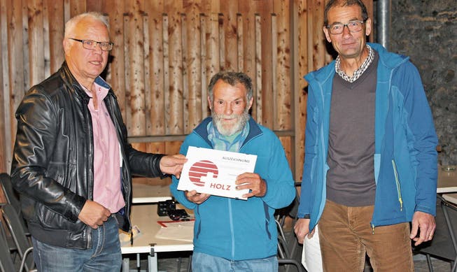 Architekt Felix Widmer, Schindelmacher Emil Näf sowie Regionalförster Erwin Rebmann (von links) bei der Übergabe des Labels «Herkunftszeichen Schweizer Holz». (Bild: PD)