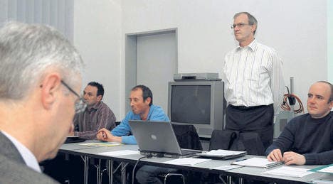 IG Präsident Peter Schmid (stehend) und weitere Vorstandsmitglieder. Links im Bild der Herisauer Gemeindepräsident Paul Signer. (Bild: dan)