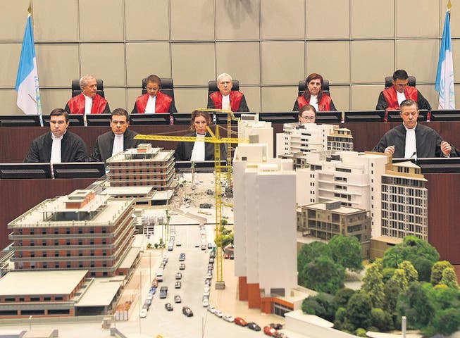 Die Richter in Den Haag beim Prozessauftakt &ndash; im Vordergrund ein Modell, das den Anschlag auf Hariri am 14. Februar 2005 in Beirut darstellt. (Bild: ap/Toussaint Kluiters)
