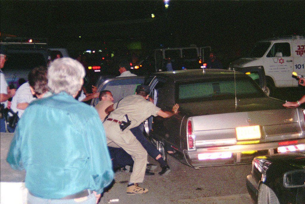 Israelische Sicherheitskräfte tragen den verletzten, am Boden liegenden Rabin in ein Auto. (Bild: Keystone)