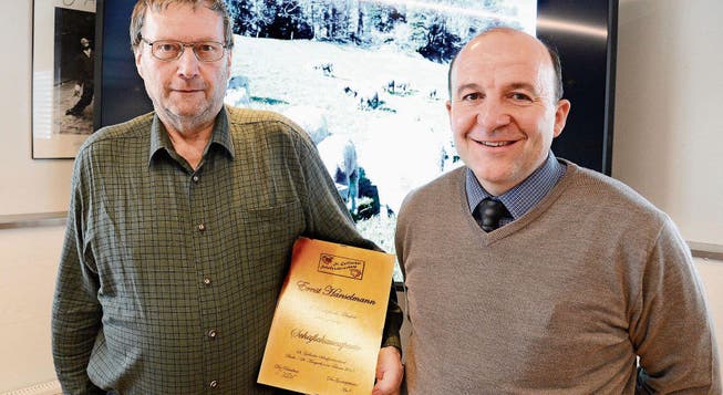 Der langjährige Schafschauexperte Ernst Hanselmann (links) hat von Verbandspräsident Martin Keller die Urkunde erhalten. (Bild: Hansruedi Rohrer)