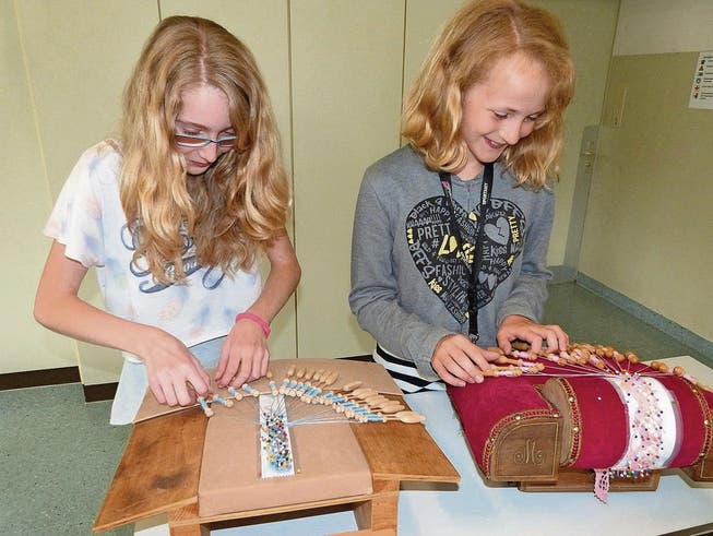 Céline und Sarah lernen im Fach «Textiles Werken» das Klöppeln, eine alte Handwerkskunst. (Bild: Kurt Lichtensteiger)