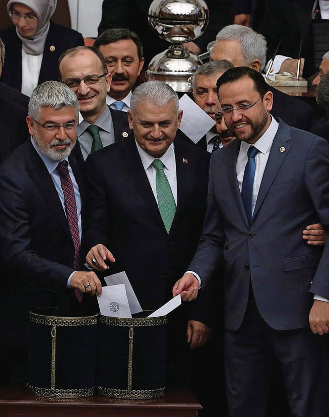 Binali Yildirim (Mitte), der designierte neue Premier der Türkei, stimmt im Parlament gegen die Immunität. (Bild: ap/Burhan Ozbilici)