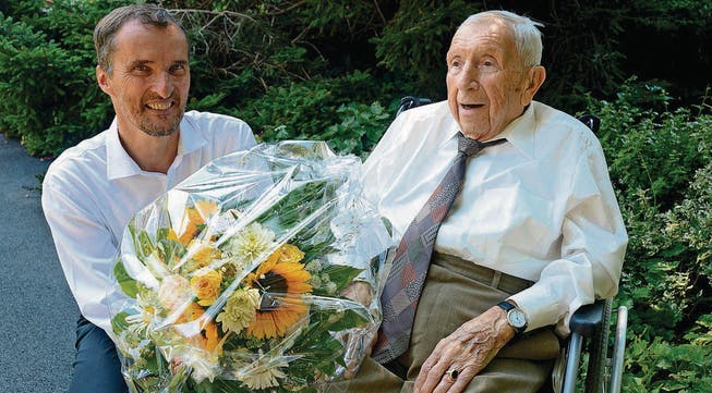 Gemeindepräsident Roland Ledergerber überbringt Hans Tribelhorn Blumen und die besten Glückwünsche zum 100. Geburtstag. (Bild: Hansruedi Rohrer)
