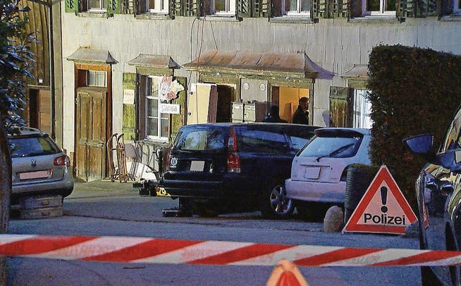 Fahnder der St. Galler Kantonspolizei am Mittwochabend vor dem Haus des Opfers in Lichtensteig. (Bild: newspictures/Beat Käslin)