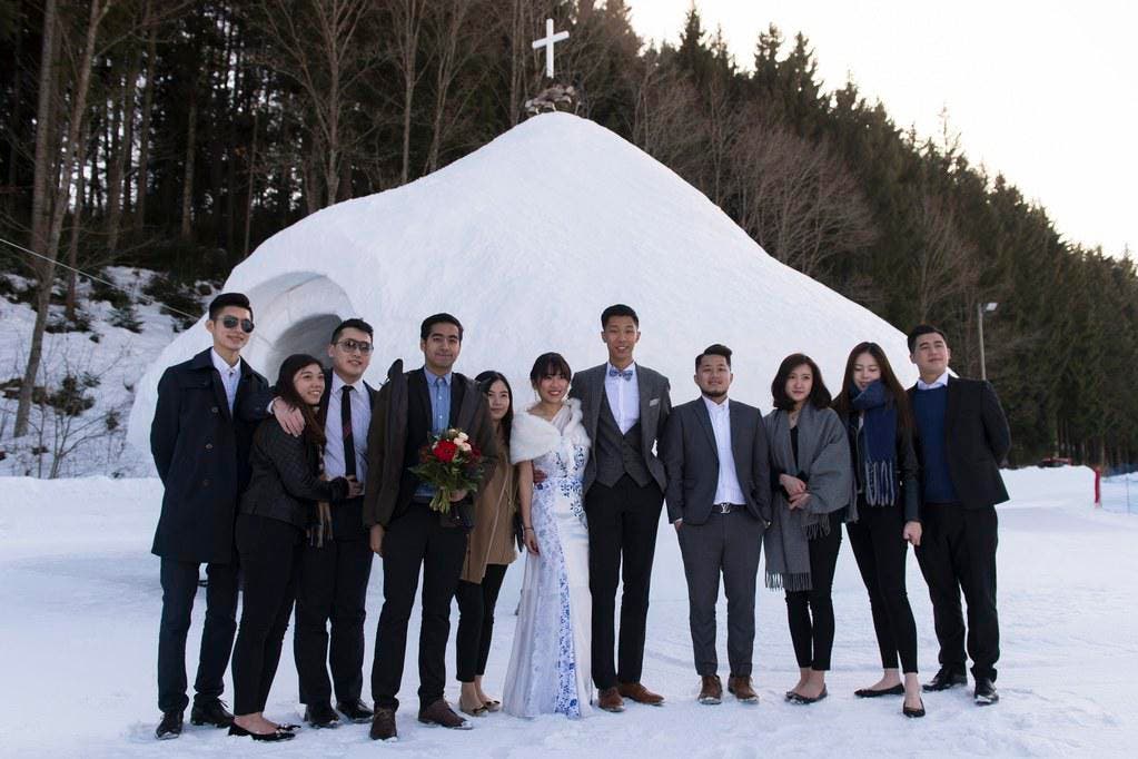 Brautpaar und Gäste posieren vor der Eiskapelle. (Bild: Keystone)