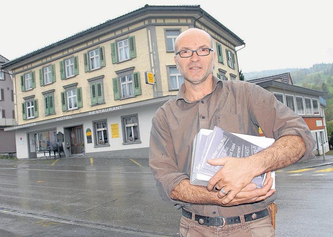 Kunsthallen-Präsident Roland Rüegg verteilt schon mal Plakate zur Kunstaktion. Im Hintergrund das Hotel-Restaurant Post in Ebnat-Kappel, wo das Kultur-Hotel im Juni eine Woche Gastrecht hat. (Bild: Hansruedi Kugler)