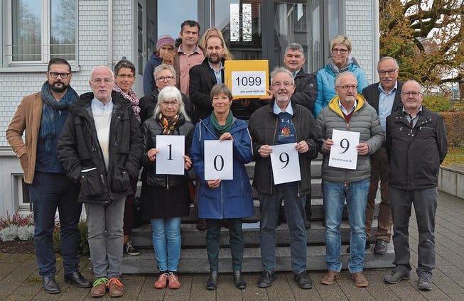 Das überparteiliche Komitee rund um Patrik Louis übergibt Gemeindepräsident Siegfried Dörig die Petition. (Bild: Martin Schneider)