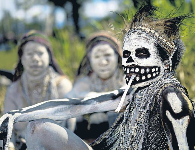 Vorchristliche Traditionen und Glaube an Magie: Eine als Skelett bemalte Frau raucht bei einem Ritual in Papua-Neuguinea. (Bild: getty/Eric Lafforgue)