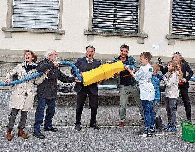 Mitglieder des Vereins Solardorf Rehetobel (links) schliessen die Schule symbolisch an die Solaranlage an. (Bild: gia)