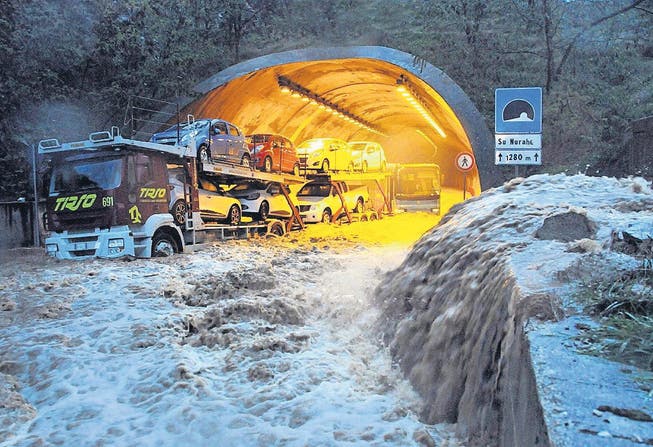 Ein Lastwagen und ein Bus bleiben wegen der grossen Wassermengen in einem Tunnel in der Nähe von Olbia stecken. (Bild: ap/Massimo Locci)
