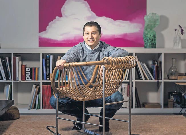 Andreas Bechtiger mit seinem Lieblingsmöbel: Er schaut den Stuhl lieber an, Sohn Nik schaukelt gerne darin. (Bild: Michel Canonica)