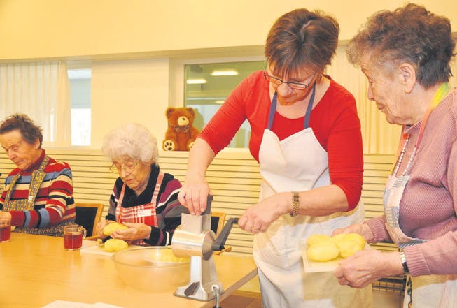Kochen im Alterszentrum in Bussnang: Marianne Jöhr gibt Anweisungen fürs Reiben. Aber um das Kartoffelschälen von Hand kommen die Frauen nicht herum. (Bild: Werner Lenzin)