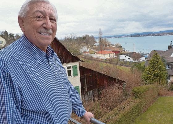 Blick auf Bauland: Willy Graf steht auf seinem Balkon. Im Hintergrund zeigen Visiere an, wie hoch und nah an bestehende Häuser gebaut wird. (Bild: Gudrun Enders)