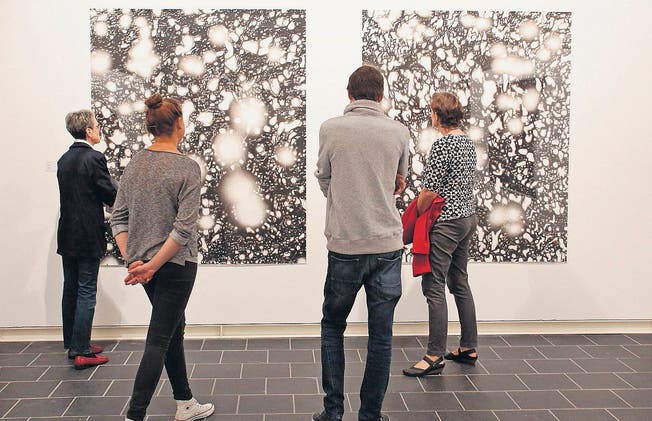 Ein Blick ins Weltall im Bauch des Thurgauer Kunstmuseums: Staunende Besucher vor den Aquarellen Helmut Wenczels. (Bild: Donato Caspari)