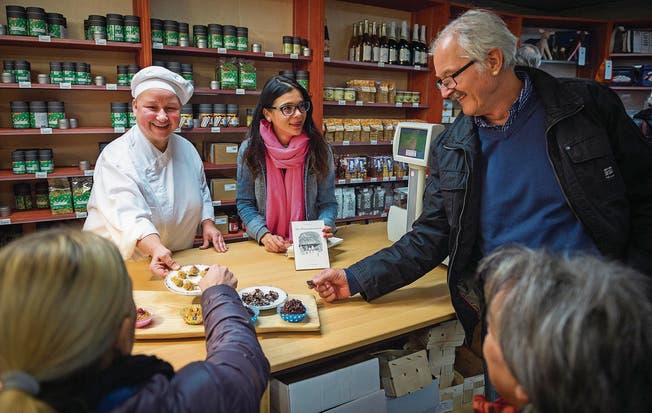 Renate Angino verteilt Köstlichkeiten an die Besucher im Ekkharthofladen, während Autorin Tanja Kummer ihr Buch bewirbt. (Bild: Andrea Stalder)