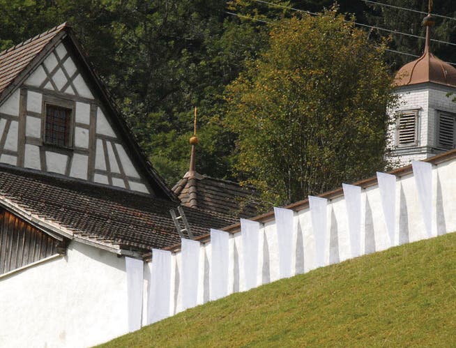 Die ersten acht Fahnen hängen an der Mauer des ehemaligen Klosters St. Maria der Engel oberhalb Wattwils. Bis zum 7. November werden nach und nach weitere Fahnen die gesamte Mauer schmücken. (Bild: Hansruedi Kugler)